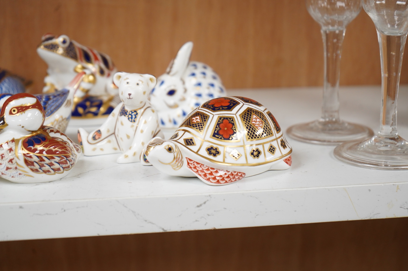A collection of Royal Crown Derby Imari pattern paperweights, to include penguin and badger, together with three Doulton flambé animals, largest 19cm wide